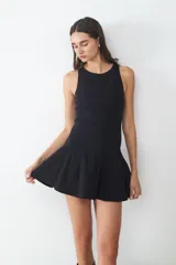Vestido corto sin mangas con cuello redondo, diseño entallado en el torso y falda con vuelo tipo peplum. Cuenta con cierre invisible en la espalda.