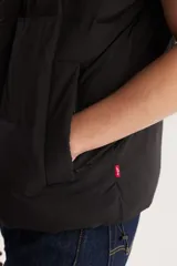 Chaleco puffer negro con cuello alto y cierre frontal con botones a presión.