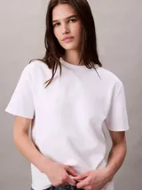 Remera Calvin Klein de algodón interlock color blanco, con cuello redondo, manga corta y emblema geométrico bordado en el pecho.