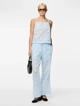 Pantalón celeste con broderie anglaise con cortes ovalados, cintura media y corte recto.