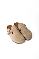 Mocasines negros de cuero con hebilla dorada y suela de corcho.