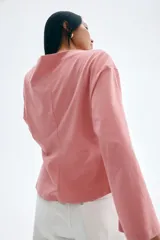 Remera rosa de algodón con escote barco y mangas largas acampanadas.