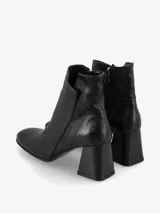 Botín de cuero negro con punta fina y cierre lateral. El tacón es ancho y de madera.