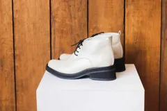 Botinetas de cuero color crema con cordones negros, suela track y plataforma.