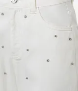 Pantalón mom comfort de cintura alta confeccionado en sarga color crudo, con trabillas en la cintura, cierre tradicional, bolsillos y brillo aplicado con lunares metalizados y pedrería de strass.