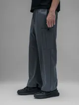 Pantalón cargo de corte oversize confeccionado en microfibra técnica. Presenta cintura elástica, bolsillos laterales y un bolsillo cargo con cierre de broche snap. Incluye un sistema de elásticos con tancas en los tobillos para regular la apertura y la silueta.
