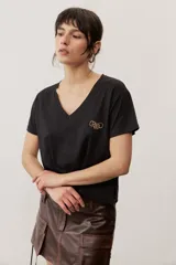 Remera de manga corta color negro, de corte clásico y escote en V, con sutil detalle bordado en el pecho.