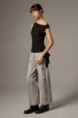 Blusa de poliéster negra, sin mangas, con cuello asimétrico, detalles bordados y sutiles lentejuelas.