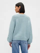 Buzo de punto de algodón con cuello redondo, mangas largas con hombros caídos y puños y ruedo acanalados. Diseño de corte holgado.