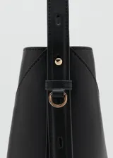 Bolso tipo hobo color negro, de diseño estructurado con costuras decorativas en forma de V invertida en el frente y una sola asa fija para llevar al hombro.