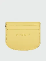 Tarjetero de cuero color amarillo, modelo Le Pliage Xtra de Longchamp, con diseño plegable y cierre de botón a presión.
