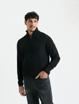 Sweater de punto inglés color verde, con cuello alto y cierre frontal parcial metálico. Diseño de manga larga con puños y ruedo acanalados.