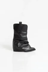 Botas texanas de cuero negro con diseño de caña arrugada y puntera fina. Presentan un taco cuadrado de altura media y tiradores laterales en la parte superior de la caña.