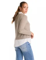 Buzo combinado marca Rio & Rian, con diseño de efecto capas que simula una camisa blanca debajo. Presenta un cuerpo de tejido de hilado fino en color beige con escote en V, y cuello y ruedo de gasa blanca.