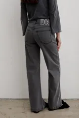 Pantalón de jean negro de corte recto y tiro medio, con cierre frontal de botón y cremallera, y bolsillos laterales y traseros.