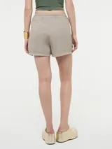 Short color marrón con rayas verticales plateadas, pretina elástica con cordón ajustable y bolsillos laterales.