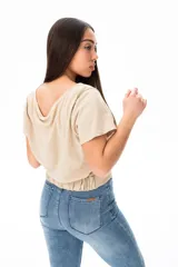 Remera beige de algodón y elastano, con escote redondo y corte a la cintura con lazo lateral.