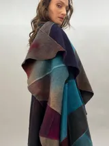 Capa de lana merino afieltrada, con diseño de espiral en tonos azul, marrón, gris y borgoña.