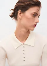 Jersey de punto fino mezcla de lana, color crudo, con cuello polo y cierre frontal de botones, de diseño canalé entallado y manga larga.