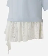 Remera overboxy de algodón color celeste, con cuello redondo, mangas cortas amplias y bajo asimétrico con aplicación de encaje blanco.