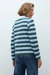 Remera de manga larga con diseño de rayas horizontales en tonos verde inglés y celeste, con cuello polo en color blanco y cierre frontal parcial con botones.