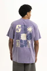 Remera de corte oversize y estilo vintage con efecto lavado, color violeta, con cuello redondo y estampa pequeña central con motivos florales y geométricos.