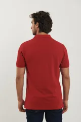Polo de piqué color rojo, manga corta, con cuello y tapeta de botones al tono.