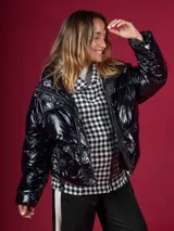 Campera puffer negra de nylon con cuello alto y cierre frontal. Interior con estampado de pata de gallo en blanco y negro.