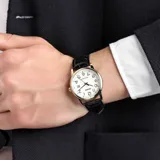 Reloj analógico Casio con caja redonda de acero inoxidable en tono dorado y esfera blanca con números arábigos negros. Cuenta con visor de fecha y correa de cuero negro con textura de cocodrilo.