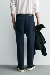Pantalón de corte carrot fit confeccionado en tejido de algodón con estructura diagonal y efecto lavado. Presenta bolsillos frontales con bolsillo cerillero, bolsillos traseros de plastrón y cierre frontal con cremallera y botón.
