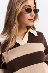 Buzo de tejido liviano con diseño de rayas horizontales en azul marino y gris, cuello tipo polo en color crema y mangas largas.