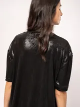 Remera blanca oversized de tela elastizada con tajos laterales y escote redondo.