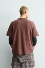 Camiseta de punto relaxed fit de algodón color bordó con efecto lavado, cuello redondo y manga corta.