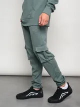 Pantalón cargo gris melange de algodón, poliéster y elastano, con bolsillos laterales tipo parche en las piernas y puños ajustados en los tobillos.