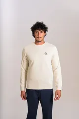 Buzo de cuello redondo en color beige claro, confeccionado en tejido de algodón. Presenta un diseño minimalista con el logo bordado de la marca en el pecho y puños acanalados.