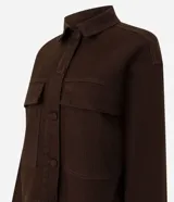 Campera de sarga acanalada color marrón, con cuello camisero estructurado, cierre frontal con botones, mangas largas con puños y bolsillos delanteros con solapa.