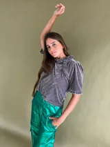 Remera gris de terciopelo con cuello alto y mangas cortas con volados.