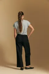 Pantalón de vestir negro con corte recto y tiro medio-alto, confeccionado con líneas sastreras limpias y bolsillos laterales.