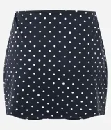 Short pollera deportivo negro con estampa de lunares blancos, confeccionado en microfibra con cintura alta y short interno integrado.