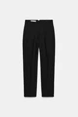 Pantalón tobillero de tiro alto y corte slim fit, con patrón de cuadros pequeños en tonos beige y negro. Presenta bolsillos delanteros de vivo y costuras marcadas en la parte delantera y trasera.