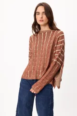 Sweater de punto con diseño de rayas verticales en relieve y textura trenzada, color terracota y beige. Presenta cuello redondo, corte holgado y diseño cropped.