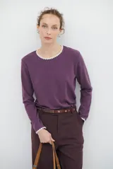 Remera de manga larga color violeta, con cuello redondo y puños decorados con un delicado borde bordado a contratono en color blanco.