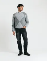 Sweater de punto con diseño de rombos en gris y azul marino, escote redondo a la base, manga larga y terminaciones en punto acanalado en cuello, puños y ruedo.