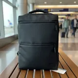 Mochila de viaje color negro con múltiples compartimentos, bolsillos frontales con cierre, puerto USB integrado y diseño resistente al agua.