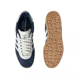 Championes adidas Gazelle de diseño clásico, confeccionados en gamuza azul con las icónicas tres tiras laterales en blanco. Presentan detalles en blanco en el talón y la lengüeta, con el nombre del modelo en dorado y una suela de goma color caramelo.