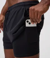 Bermuda deportiva Get Over de poliamida negra, con acabado exterior perforado, cintura elástica con cordón ajustable y short interior de compresión.
