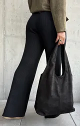 Pantalón de tejido de punto acanalado en color negro, con corte recto y ligeramente acampanado en el bajo. Presenta una cintura elástica con cordón ajustable y terminaciones con herrajes metálicos.