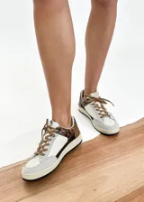 Championes urbanos de cuero vacuno color blanco, con detalles en gris y marrón con estampado animal print. Interior forrado en textil acolchado y cordones marrones.