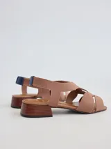 Sandalia de diseño minimalista con tiras anchas de neopreno negro, taco bajo de madera y detalle de tira trasera en color suela.