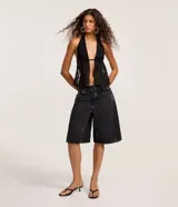 Bermuda estilo jorts de jeans color negro gastado, con trabillas en la cintura, cierre tradicional, cinco bolsillos y detalles de recortes.